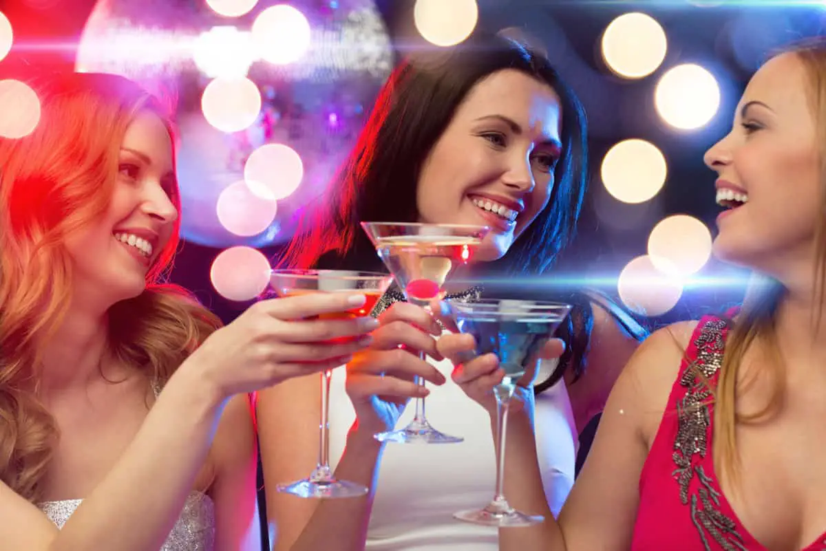 three women enjoying cocktails from the bar