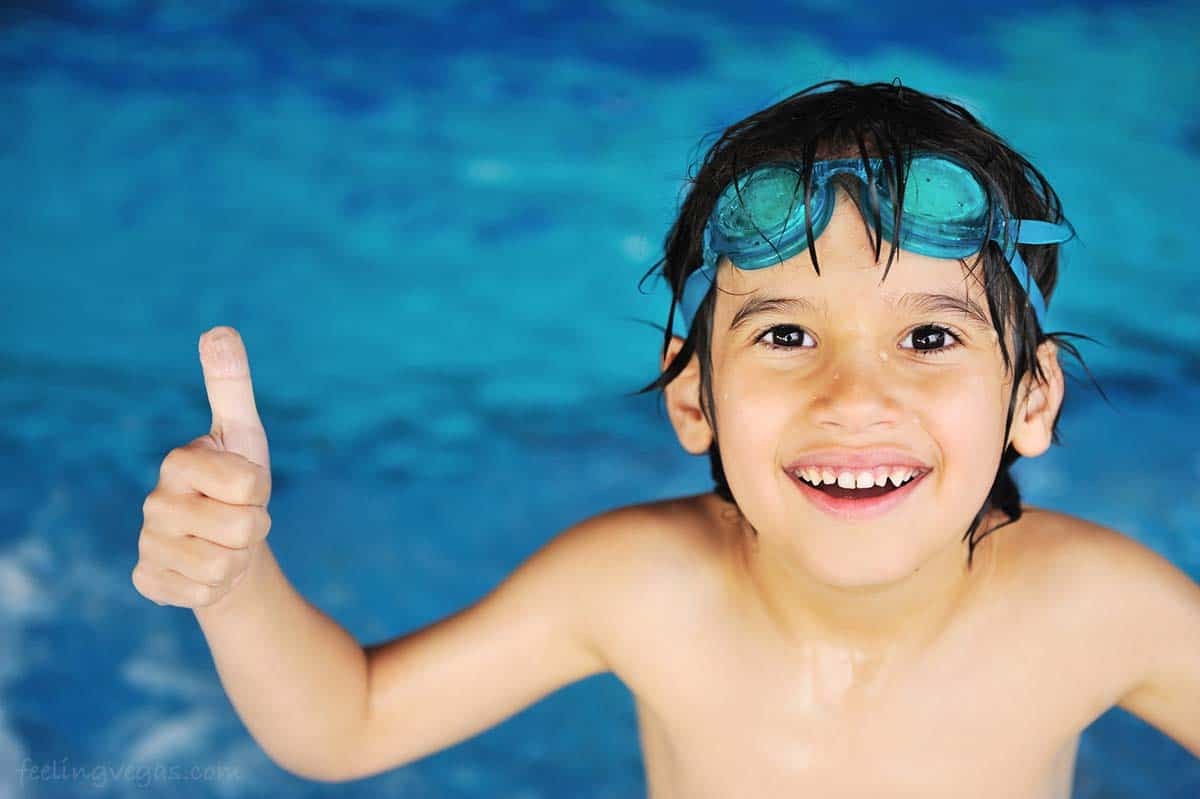 Young boy giving a thumbs up at the indoor swimming pool