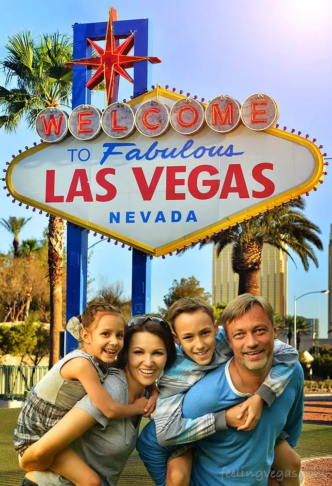 Family with kids in front of Las Vegas sign.