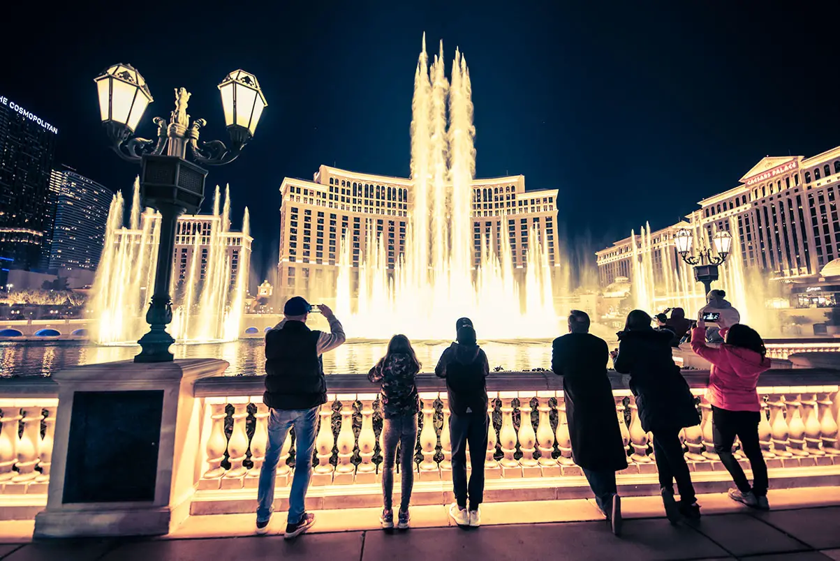 Tourists at Bellagio Fountains at night on the Las Vegas Strip.