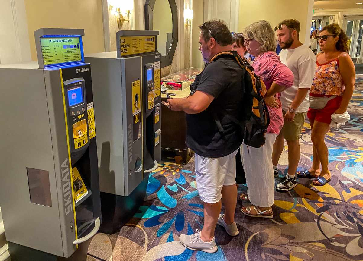 guests paying the bellagio parking fee at a kiosk before entering the parking garage