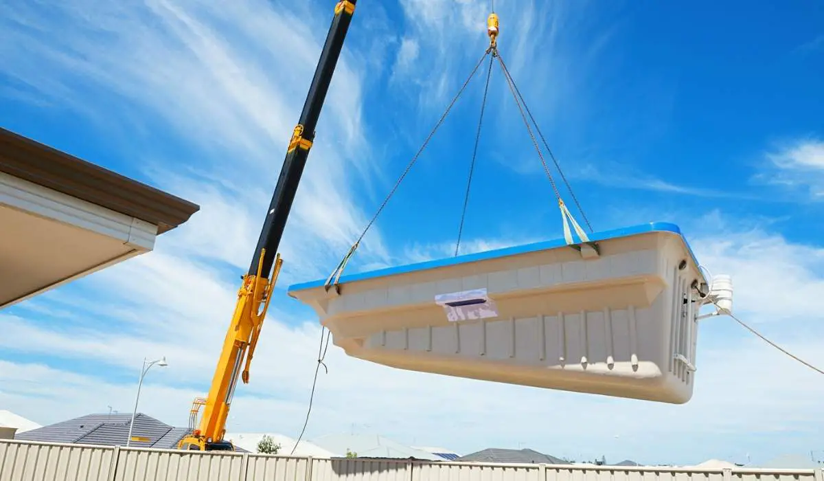 A fiberglass pool being lifted by a crane into a Las Vegas backyard.