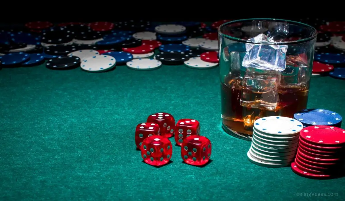 Whiskey on the rocks on casino gaming table with dice and poker chips