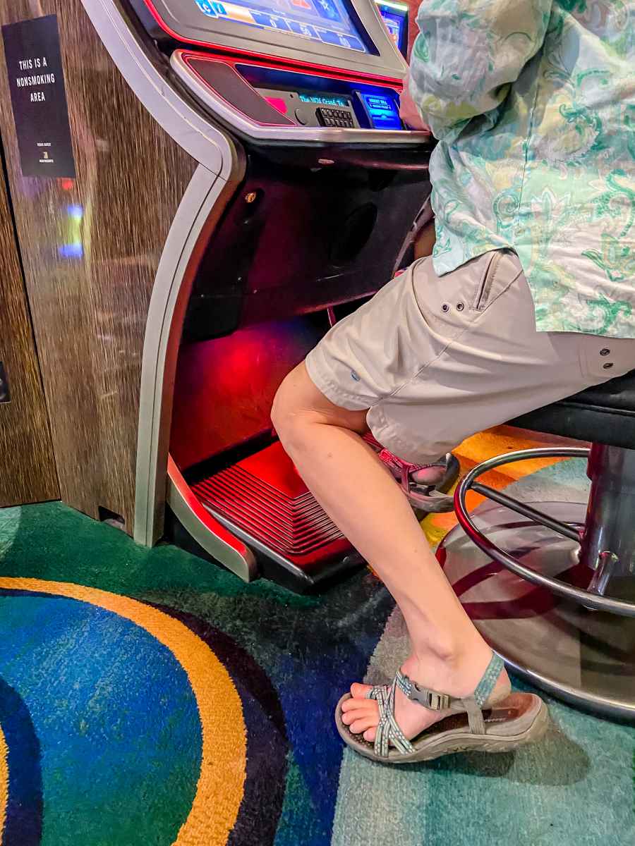 A woman wearing shorts in a Las Vegas casino while playing a slot machine