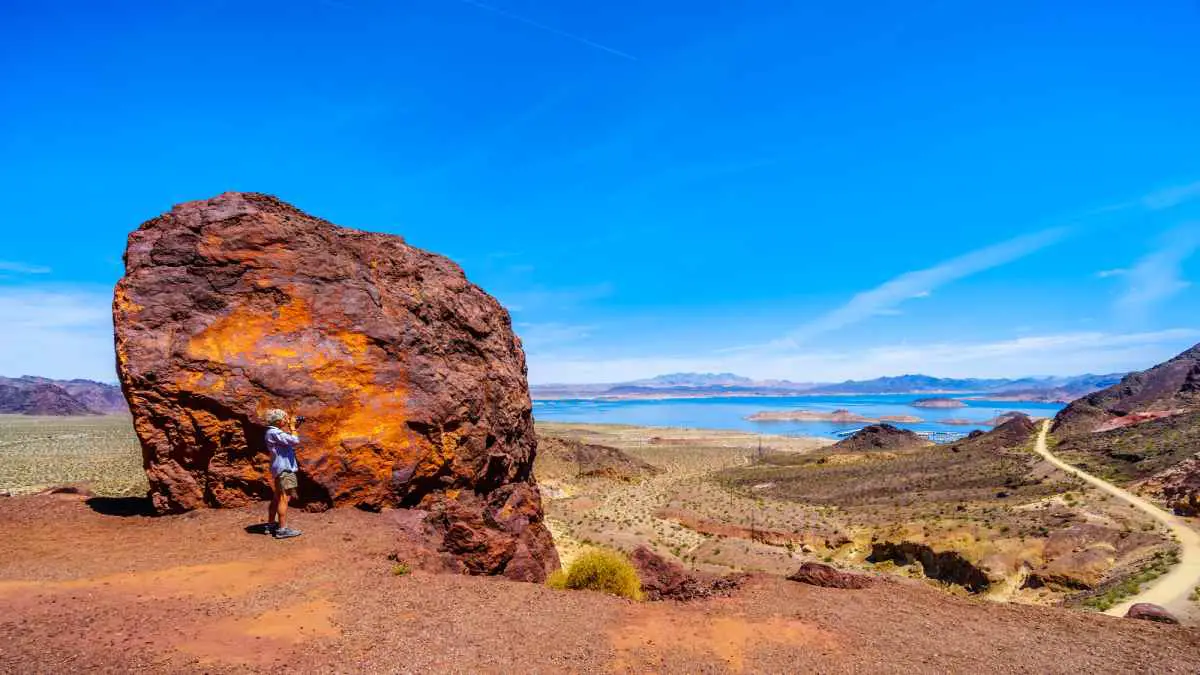 A hiker on the historic Railroad Trail with a view of Lake Mead in the distance.