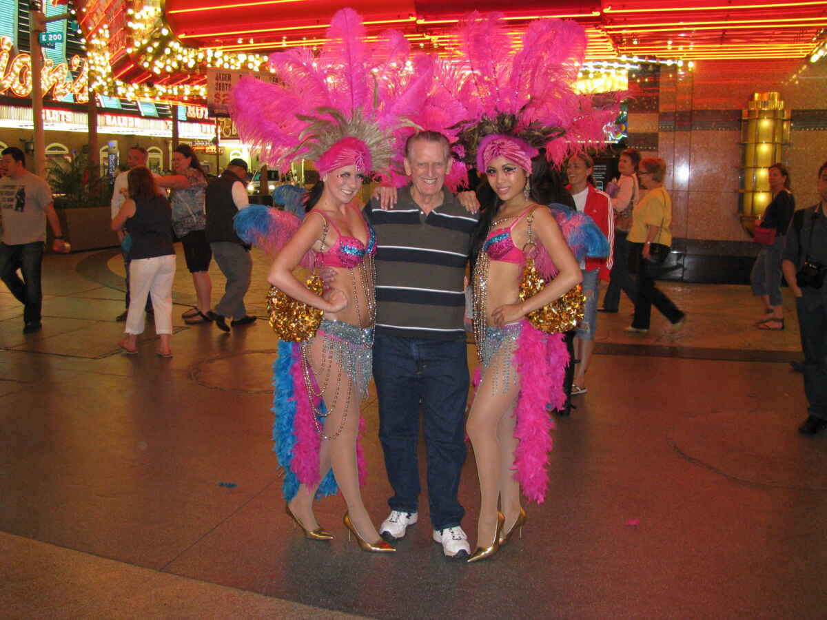 Las Vegas showgirls take a picture with a tourist on Fremont St.